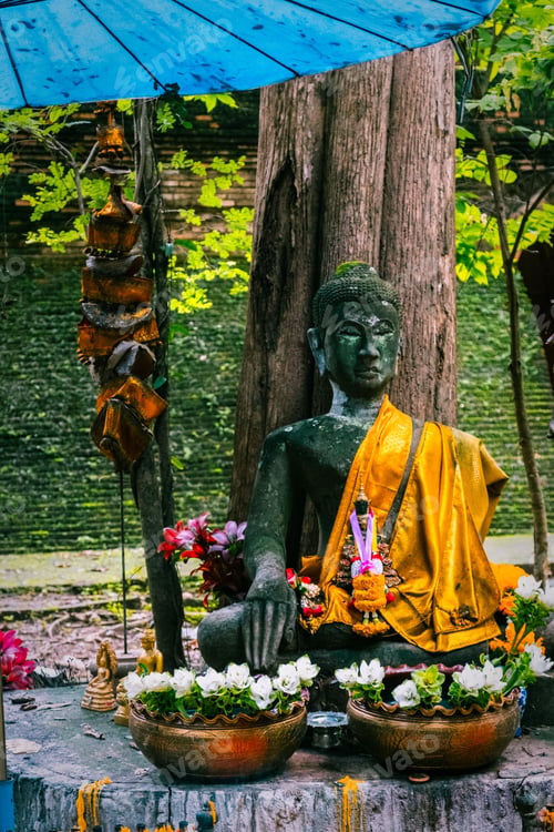 Preview: Serene Buddha statue with offerings in garden.