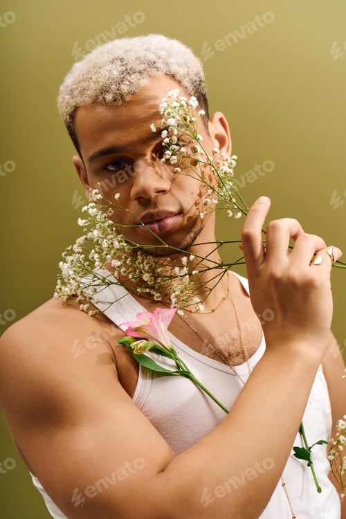 Preview: Young african american man stylishly posing with flowers in trendy studio setting