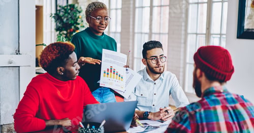 Preview: multicultural people collaborating on infographic startup project analyzing statistics