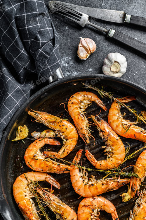 Preview: Grilled giant langoustine shrimps, prawns in a frying pan. Black background. Top view