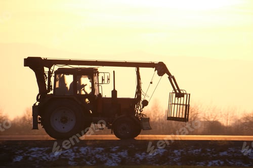 Preview: Mobile lifting crane tractor driving on intercity road at sunset