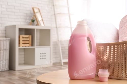 Preview: Bottle of detergent and clean towels on table indoors, space for text. Laundry day