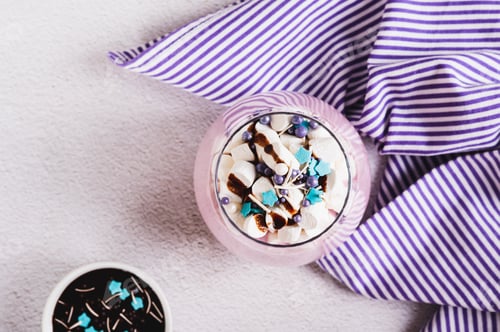 Preview: Close up of fresh berry yogurt with marshmallows and icing in a glass on table top view
