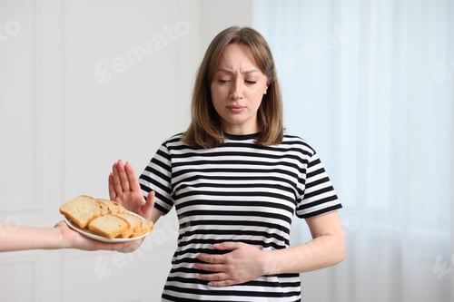 Preview: Gluten free diet. Woman refusing from bread indoors