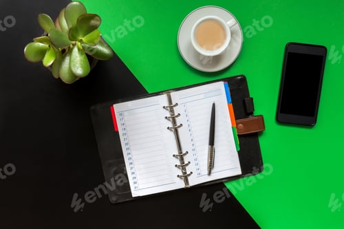 Preview: Black green office desk table with blank notebook, computer keyboard and other office supplies
