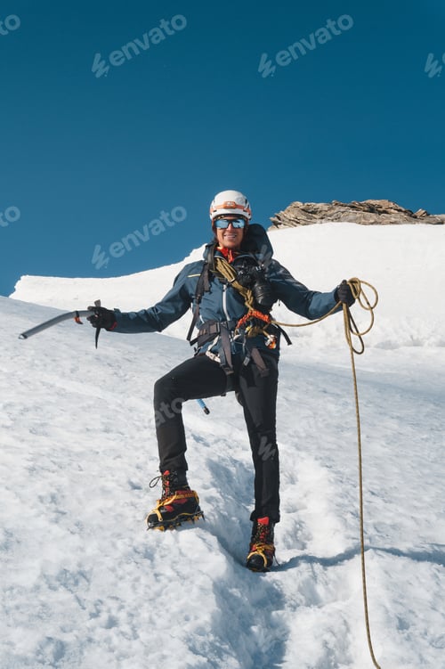 Preview: A mountaineer smiles on a snow-covered peak of the Swiss Alps,