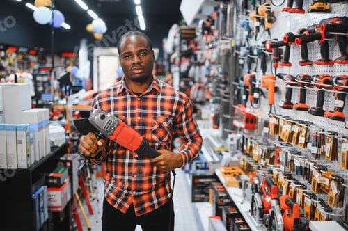 Preview: African americam man buying modern electric drill while standing in tool.
