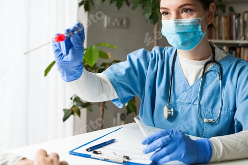 Preview: Female caucasian doctor holding a swab collection stick