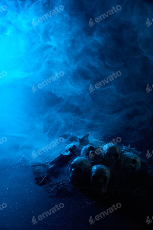 Vista previa: Halloween human skulls in abstract smoke on black background.
