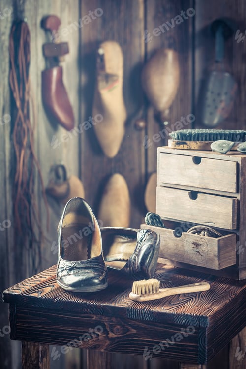 Preview: Rustic shoemaker workshop with shoes and brush