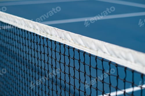 Preview: Close-up of the diagonal tennis net with white lines on a blue court, concept of a tennis match