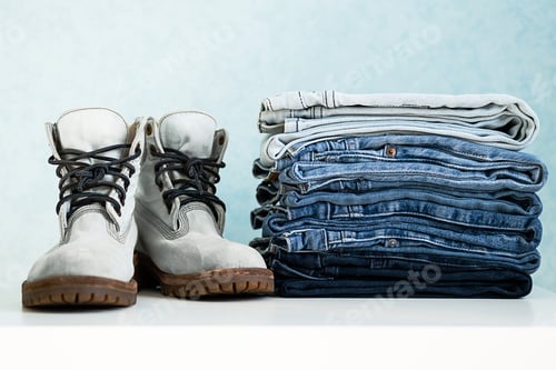 Preview: Neatly Stacked Jeans and Boots on a Table