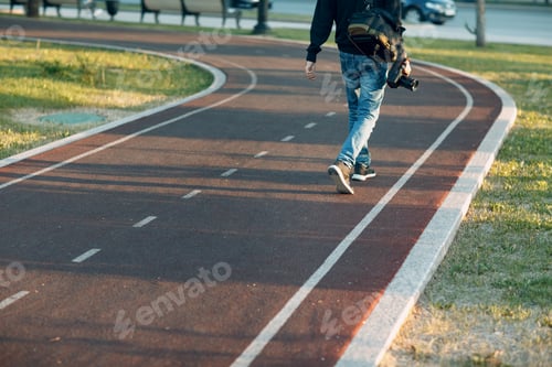 Preview: Photographer with photo camera walks on road treadmill day