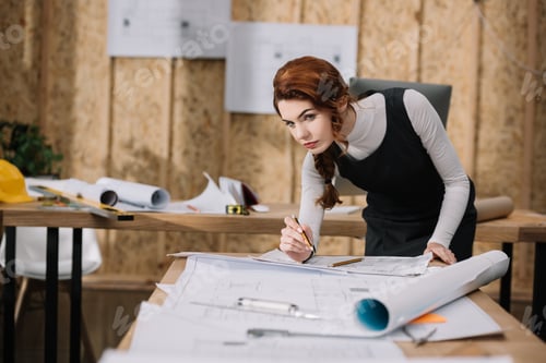 Preview: beautiful young female architect discovering building plans