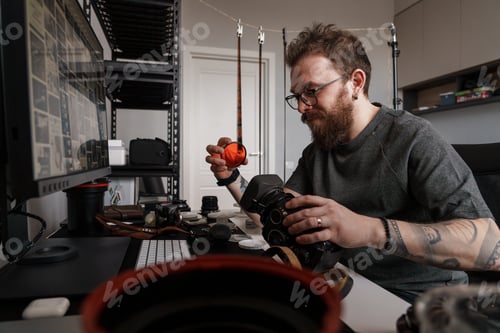 Preview: Professional photographer examining camera equipment in studio