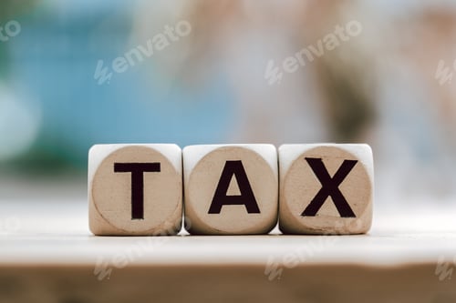 Preview: TAX concept with wooden block on wooden table background.