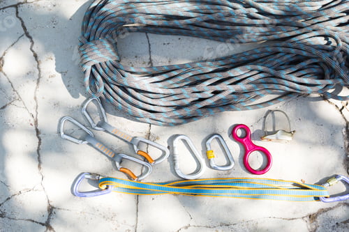 Preview: Coiled climbing rope and steel carabiner. Mountain climbing equipment: carbine,
