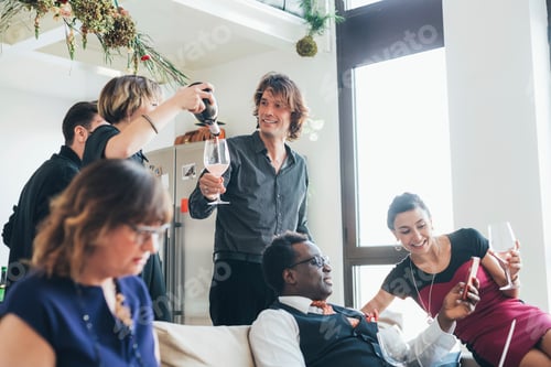 Preview: Businessmen and businesswomen celebrating with wine in loft office