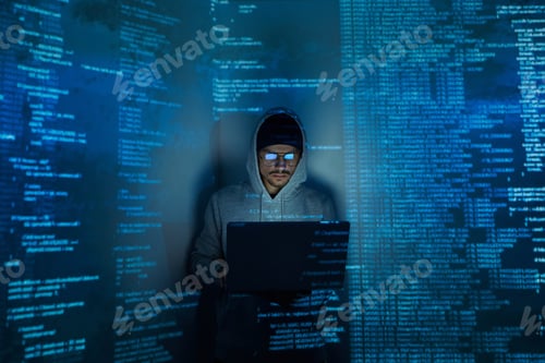 Preview: Confident young man in hooded shirt using computer while standing against dark background