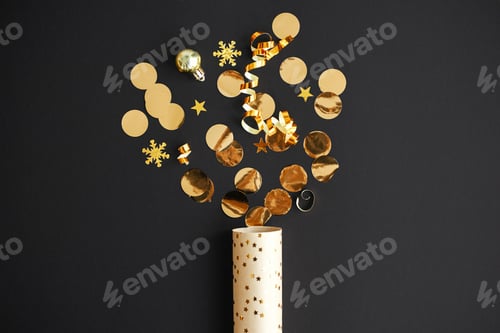 Preview: Merry Christmas and Happy New Year! Modern golden confetti firework popping on black, flat lay