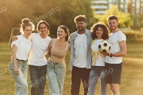 Preview: With soccer ball. Young friends are having fun on the field