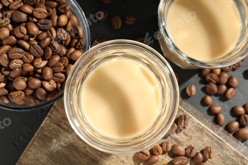 Preview: Coffee cream liqueur in glasses and beans on black table, flat lay