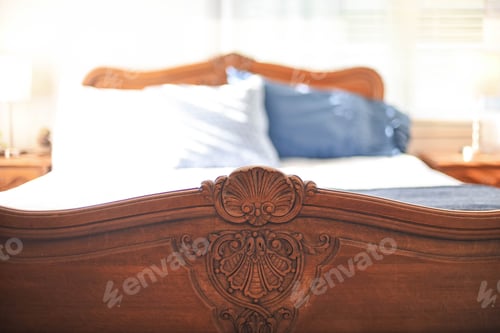 Preview: Carved detail of antique oak bed footboard in a stylish bedroom