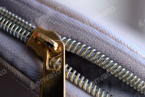 Preview: Selective focus, yellow metal zipper of a makeup bag or small purse macro pattern background