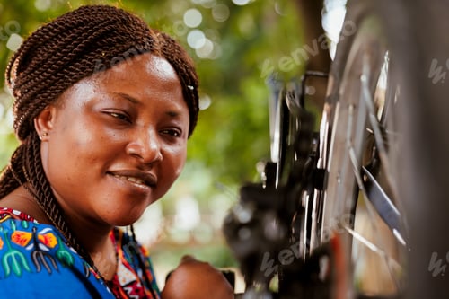 Preview: Healthy female adjusting bicycle tire