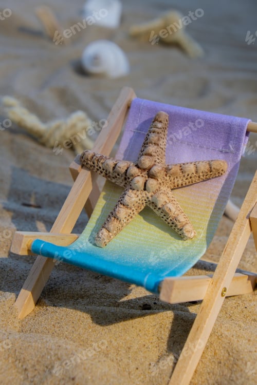 Preview: Sunny holidays on the beach with sand beach accessories with sea shells and sea star. Sun lounger