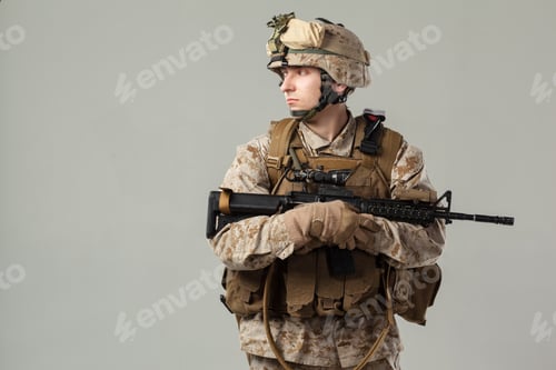Preview: Soldier stands with weapon in uniform during training session in indoor studio