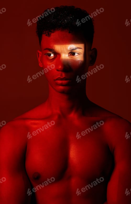 Preview: Beauty, red light and man in studio for health, wellness and skincare with a spotlight reflection.