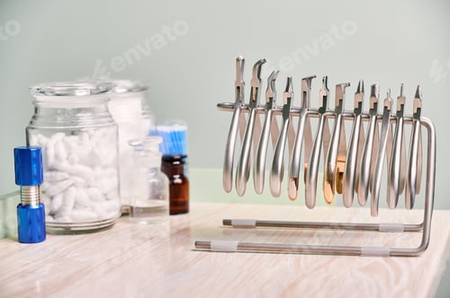 Preview: Jar of cotton rolls and orthodontic instruments for dental procedure.
