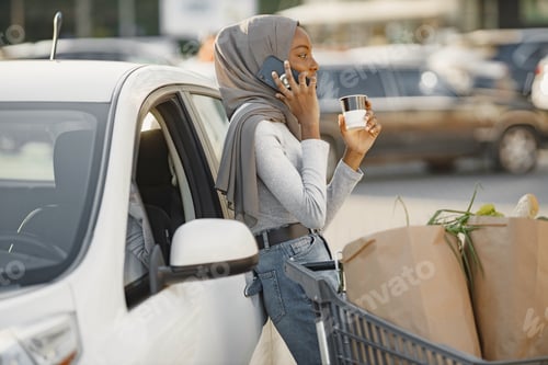 Preview: African muslim woman chraging car and use phone