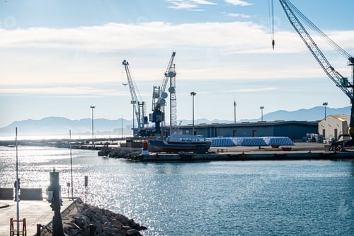 Preview: Mesmerizing view of cranes and port work area against a blue sky