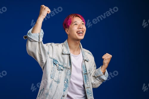 Preview: Asian boy with pink hair screaming while making winner gesture