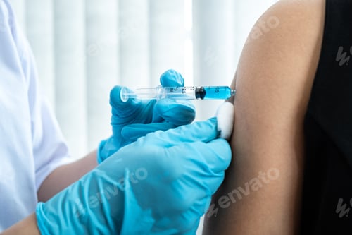 Preview: Doctor holding syringe and using cotton before injection coronavirus vaccine in shoulder of patient