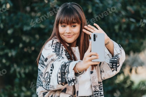 Vista previa: Joven chica caucásica streamer afuera usando un teléfono inteligente para transmitir, feliz y sonriendo