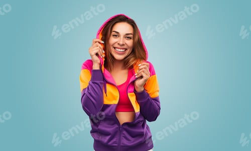 Preview: Content young sportswoman in stylish outfit smiling at camera
