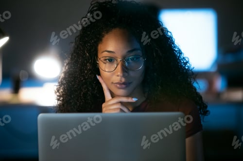 Preview: Confident young business woman working with laptop sitting in the office.