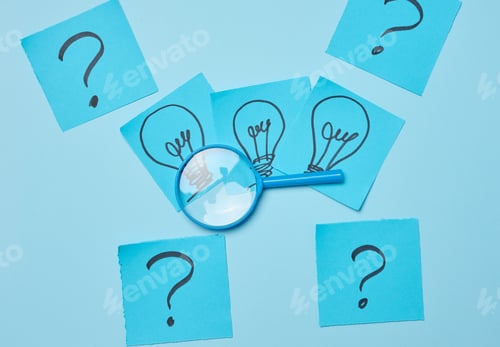 Preview: Drawn light bulbs on sheets of paper and a plastic magnifying glass