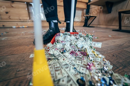 Preview: Broom sweeping dollars in scoop from on wooden floor