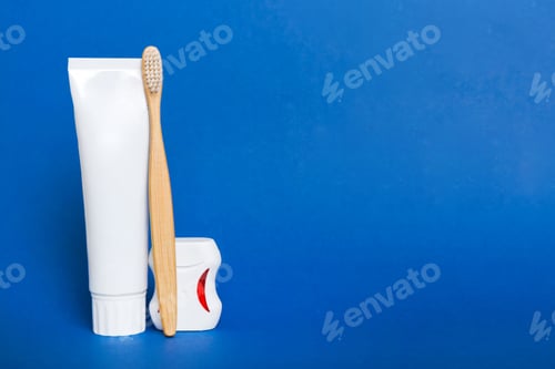 Preview: toothpaste and toothbrush top view with copy space on colored background.