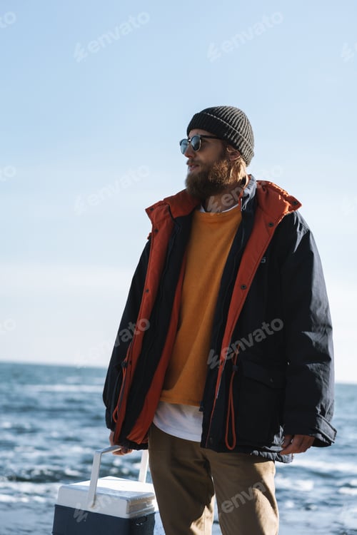 Preview: Fisherman wearing coat standing at the seashore