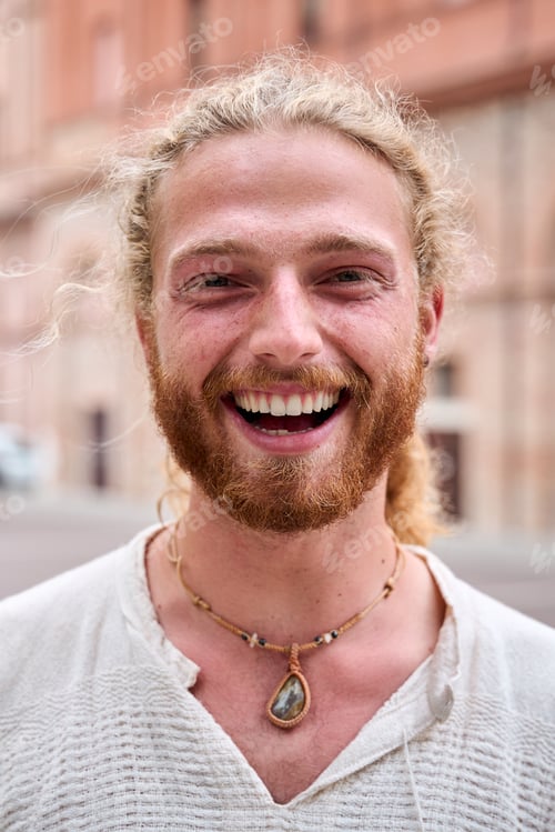 Preview: Portrait of attractive smiling young man looking at camera in park. Caucasian male handsome model.