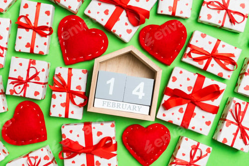 Preview: Top view of gift boxes, wooden calendar and red textile hearts on colorful background