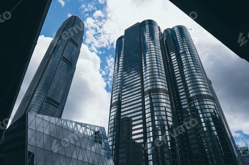 Preview: Bottom view of modern skyscrapers in business district against blue sky