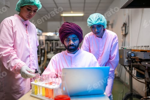 Preview: Asian scientists use test tube checking juice product in the beverage factory.