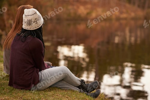 Preview: Shot of two teenage girls sitting by a lake in the early evening