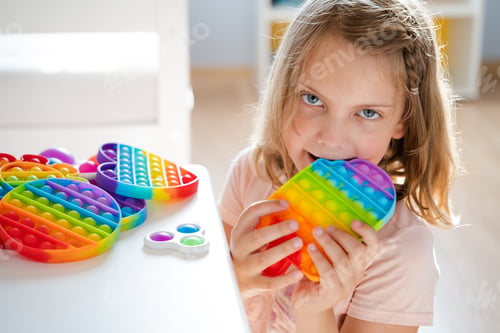 Preview: Little girl,kid,child plays with colorful pop it children's room, bedroom.Funny trendy silicone anti